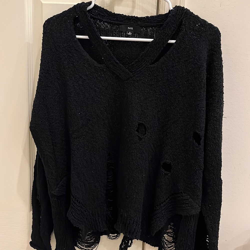 Black sweater. V neck with cuts and stylish rips on front and back.